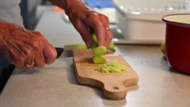 Mutfakta sebze doğrayan ve hazırlayan bir kadın. Yemek ve yemek hazırlama kavramı.