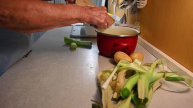 Mutfakta sebze doğrayan ve hazırlayan bir kadın. Yemek ve yemek hazırlama kavramı.