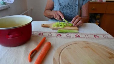 Mutfakta sebze doğrayan ve hazırlayan bir kadın. Yemek ve yemek hazırlama kavramı.