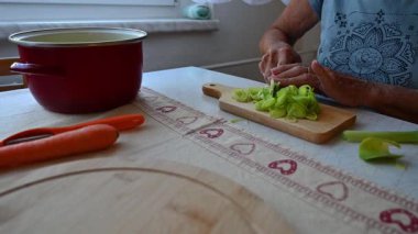 Mutfakta sebze doğrayan ve hazırlayan bir kadın. Yemek ve yemek hazırlama kavramı.