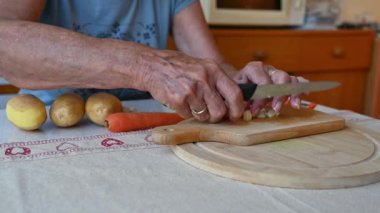 Mutfakta sebze doğrayan ve hazırlayan bir kadın. Yemek ve yemek hazırlama kavramı.
