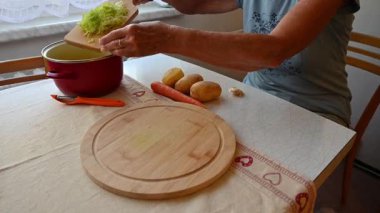 Mutfakta sebze doğrayan ve hazırlayan bir kadın. Yemek ve yemek hazırlama kavramı.