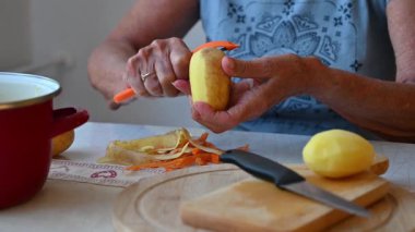 Mutfakta sebze doğrayan ve hazırlayan bir kadın. Yemek ve yemek hazırlama kavramı.