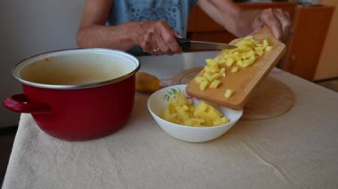 Mutfakta sebze doğrayan ve hazırlayan bir kadın. Yemek ve yemek hazırlama kavramı.