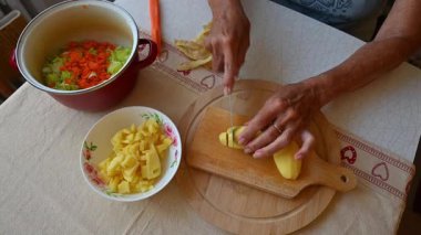 Mutfakta sebze doğrayan ve hazırlayan bir kadın. Yemek ve yemek hazırlama kavramı.