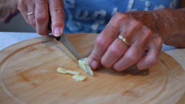 Mutfakta sebze doğrayan ve hazırlayan bir kadın. Yemek ve yemek hazırlama kavramı.