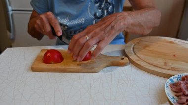Mutfakta sebze doğrayan ve hazırlayan bir kadın. Yemek ve yemek hazırlama kavramı.