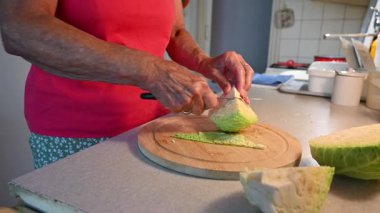 Mutfakta sebze doğrayan ve hazırlayan bir kadın. Yemek ve yemek hazırlama kavramı.