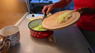 Mutfakta sebze doğrayan ve hazırlayan bir kadın. Yemek ve yemek hazırlama kavramı.