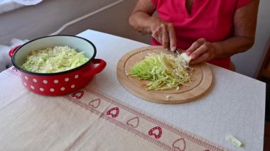 Mutfakta sebze doğrayan ve hazırlayan bir kadın. Yemek ve yemek hazırlama kavramı.