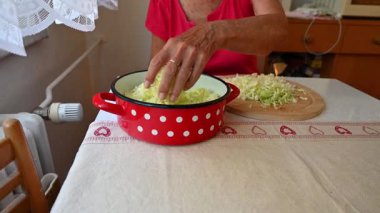 Mutfakta sebze doğrayan ve hazırlayan bir kadın. Yemek ve yemek hazırlama kavramı.