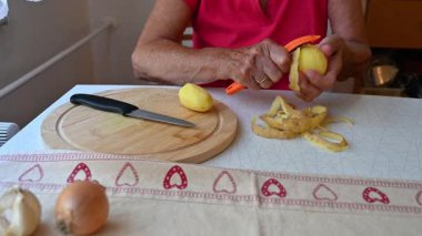 Mutfakta sebze doğrayan ve hazırlayan bir kadın. Yemek ve yemek hazırlama kavramı.
