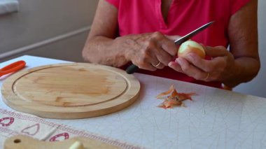 Mutfakta sebze doğrayan ve hazırlayan bir kadın. Yemek ve yemek hazırlama kavramı.