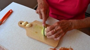Mutfakta sebze doğrayan ve hazırlayan bir kadın. Yemek ve yemek hazırlama kavramı.