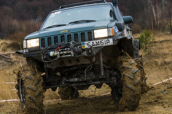Fuoristrada marchio jeep cherokee supera una pista — Foto Stock