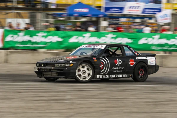 Unknown rider on the car brand Nissan overcomes the track — Stock Photo, Image