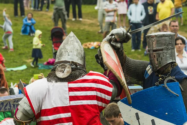 Participants of the festival in knight armor arrange fights