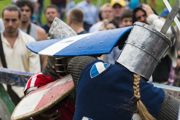 Les participants du festival en armure de chevalier organisent des combats — Photo