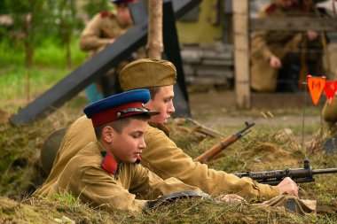 Lviv, Ukrayna 14 Ekim 2020: Askeri tarihi yeniden yapılanma, silahlı kuvvetlerin kuruluş yıldönümüne adanmıştır. Bir asker Lviv civarında makineli tüfekle ateş ediyor..