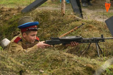 Lviv, Ukrayna 14 Ekim 2020: Askeri tarihi yeniden yapılanma, silahlı kuvvetlerin kuruluş yıldönümüne adanmıştır. Bir asker Lviv civarında makineli tüfekle ateş ediyor..