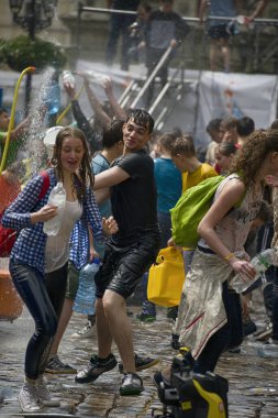 Lviv, Ukrayna - 2 Mayıs 2016: Pazartesi günü Paskalya 'dan sonra belediye binasında kutlama suyu dökülüyor. Erkek Kadın su döker.