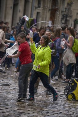 Lviv, Ukrayna - 2 Mayıs 2016: Pazartesi günü Paskalya 'dan sonra belediye binasında kutlama suyu dökülüyor. Mutlu çocuklar birbirlerine su dökerler..