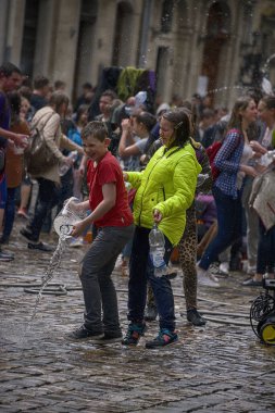 Lviv, Ukrayna - 2 Mayıs 2016: Pazartesi günü Paskalya 'dan sonra belediye binasında kutlama suyu dökülüyor. Mutlu çocuklar birbirlerine su dökerler..