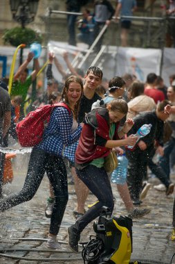 Lviv, Ukrayna - 2 Mayıs 2016: Pazartesi günü Paskalya 'dan sonra belediye binasında kutlama suyu dökülüyor. Erkek Kadın su döker.