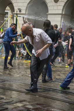 Lviv, Ukrayna - 2 Mayıs 2016: Pazartesi günü Paskalya 'dan sonra belediye binasında kutlama suyu dökülüyor. İnsanlar arasında dans eden kel adamlar.