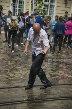 Lviv, Ukrayna - 2 Mayıs 2016: Pazartesi günü Paskalya 'dan sonra belediye binasında kutlama suyu dökülüyor. İnsanlar arasında dans eden kel adamlar.