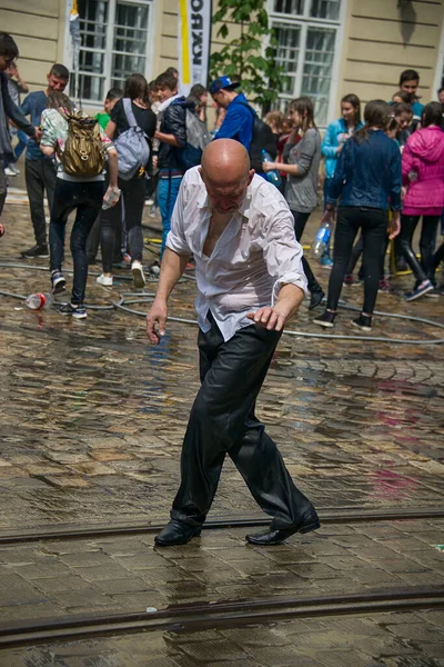 Lviv, Ukrayna - 2 Mayıs 2016: Pazartesi günü Paskalya 'dan sonra belediye binasında kutlama suyu dökülüyor. İnsanlar arasında dans eden kel adamlar.