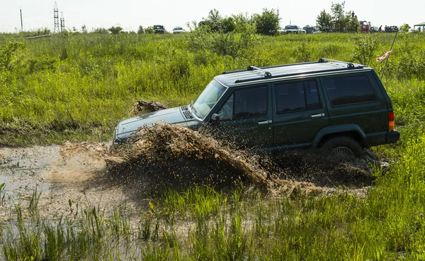 Marca de vehículos todoterreno Jeep Cherokee supera un pozo de barro — Foto de Stock