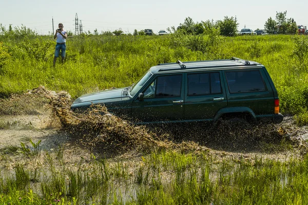 Off-road vehicle brand Jeep Cherokee overcomes a pit of mud — Stock Photo, Image