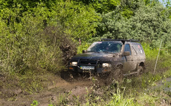 Off-Road araç marka Nissan çamur çukuru üstesinden gelir. — Stok fotoğraf