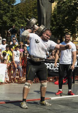 Strongman competitions raises dumbbell hand