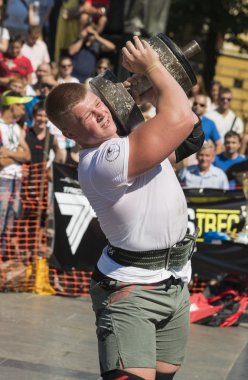 Strongman competitions raises dumbbell hand