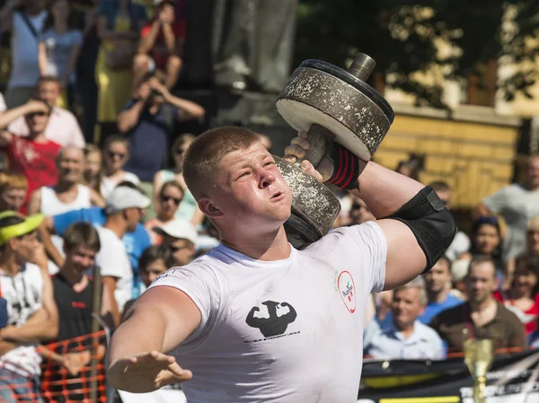 Strongman competitions raises dumbbell hand — Stock Photo, Image