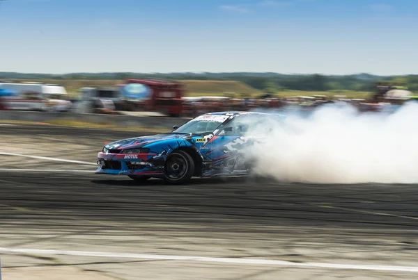 Unknown rider on the car brand Nissan overcomes the track — Stock Photo, Image