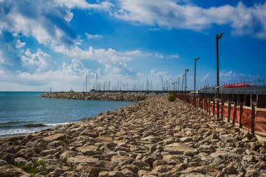 Masmavi sularda üzerinde renkli bulutlar ile parlak deniz İskelesi