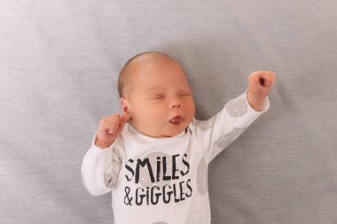 Gri arka planda yeni doğan bebek