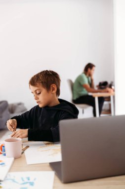 Çevrimiçi uzaktan öğrenme. Bilgisayar dersleriyle resim yapan okul çocuğu. Karantina ve koronavirüs sırasında evde eğitim.