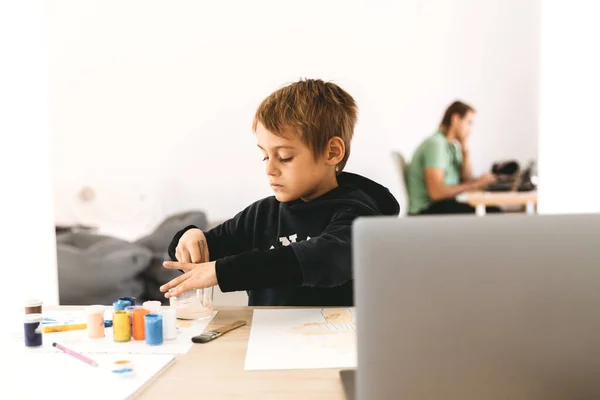 Διαδικτυακή εξ αποστάσεως μάθηση. Παιδί του σχολείου ζωγραφίζει με μαθήματα υπολογιστή. Διδασκαλία κατ 'οίκον κατά τη διάρκεια της καραντίνας και του ιού.. Royalty Free Εικόνες Αρχείου