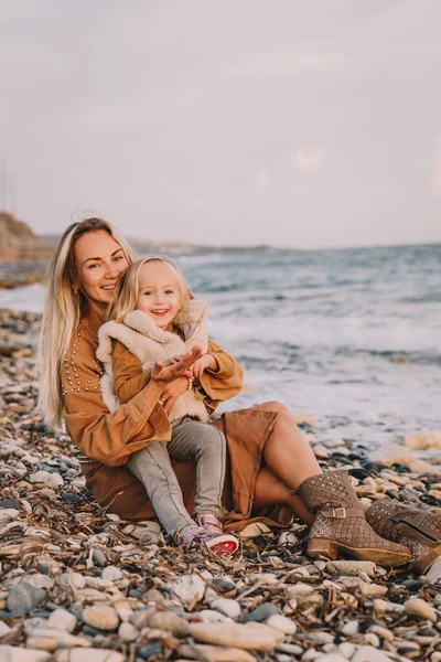 Madre con hija al lado del mar. Imagen De Stock