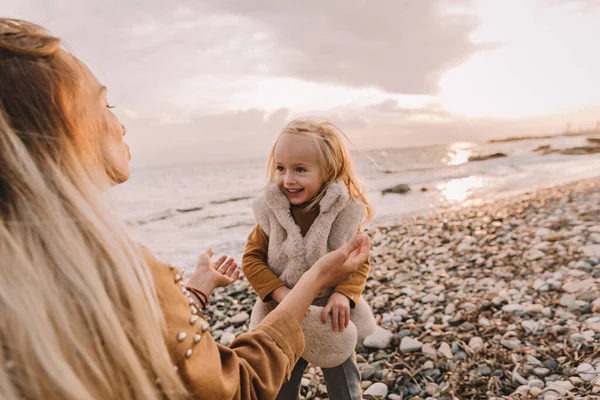 Madre con hija al lado del mar. Imagen De Stock