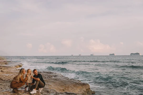 Madre, papá e hija al lado del mar. Fotos De Stock