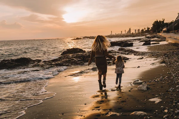 Madre con hija al lado del mar. Imágenes De Stock Sin Royalties Gratis
