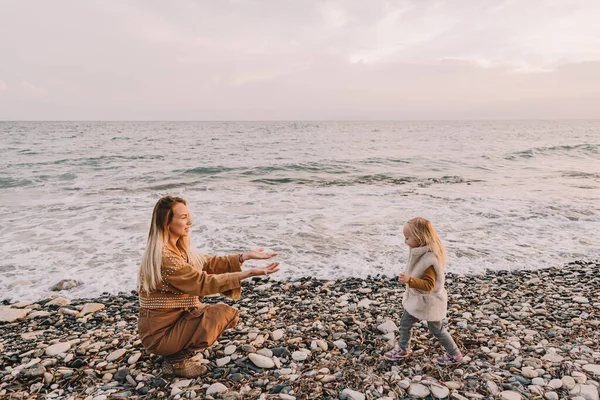 Madre con hija al lado del mar. Imagen De Stock