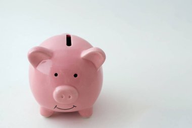 İzole edilmiş beyaz arka planda domuz şeklinde bir kumbara.