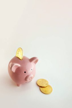 İzole edilmiş beyaz arka planda bitcoin paraları olan domuz kumbarası