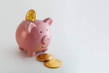 İzole edilmiş beyaz arka planda bitcoin paraları olan domuz kumbarası